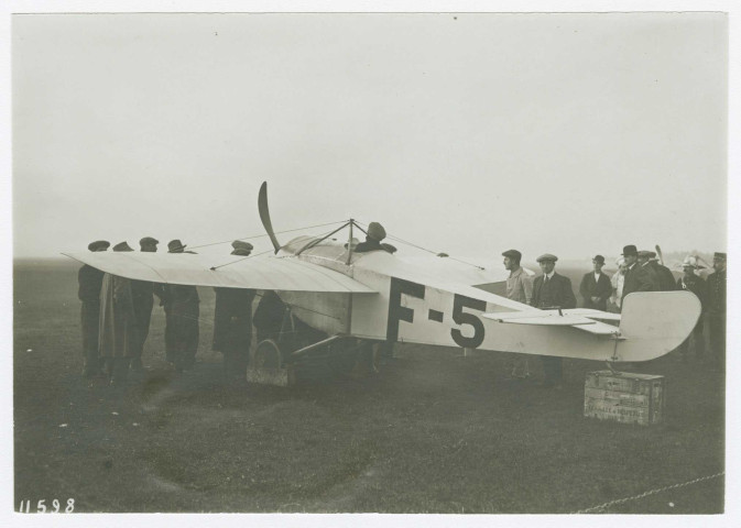 Monoplans et biplans sur la piste et près des hangars de l'aérodrome