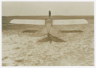 Monoplans et biplans sur la piste et près des hangars de l'aérodrome